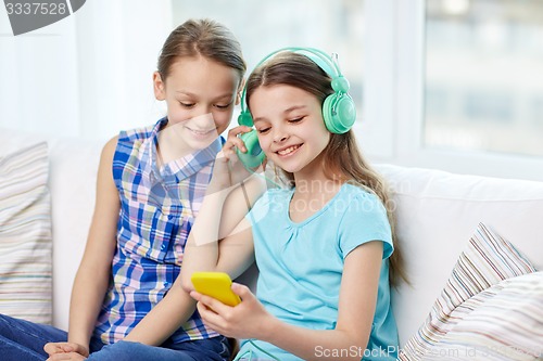 Image of happy girls with smartphone and headphones