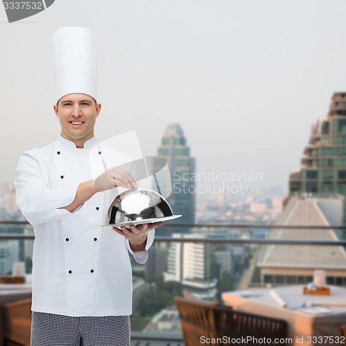 Image of happy male chef cook holding cloche