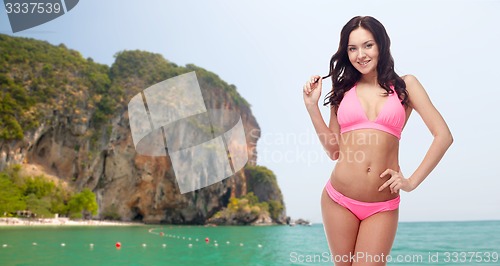 Image of happy young woman in pink bikini swimsuit