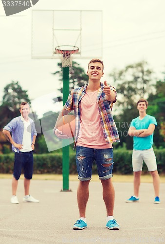 Image of group of smiling teenagers playing basketball