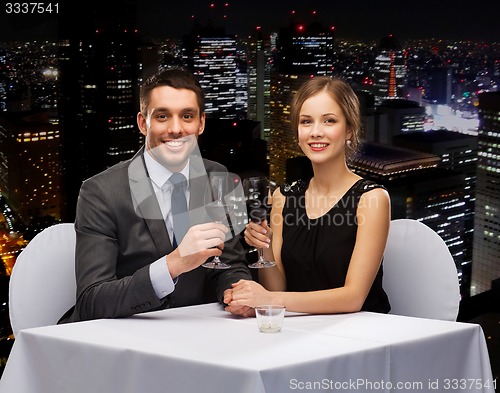 Image of young couple with glasses of wine at restaurant