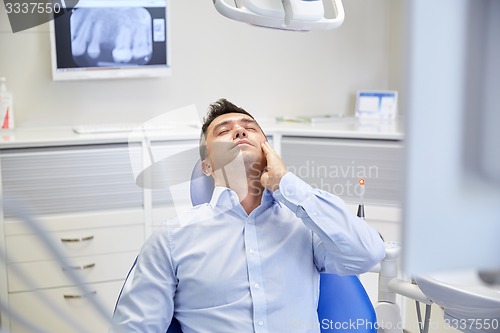 Image of man having toothache and sitting on dental chair