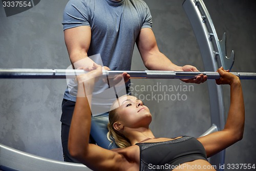 Image of man and woman with barbell flexing muscles in gym