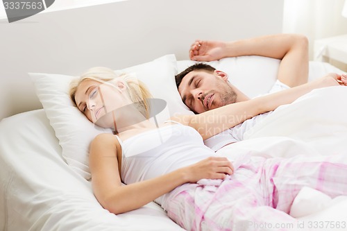 Image of happy couple sleeping in bed at home