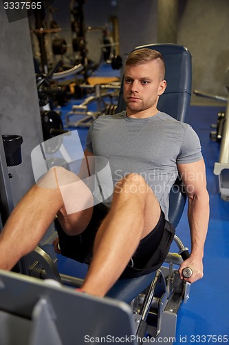 Image of man flexing leg muscles on gym machine