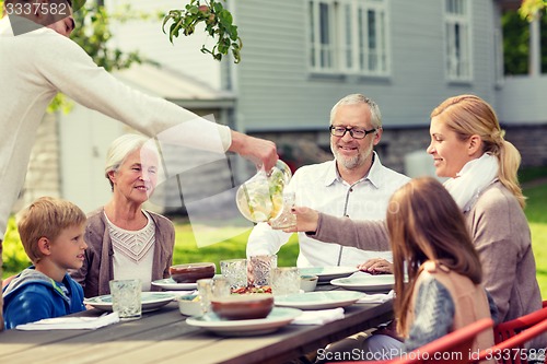 Image of happy family having holiday dinner outdoors