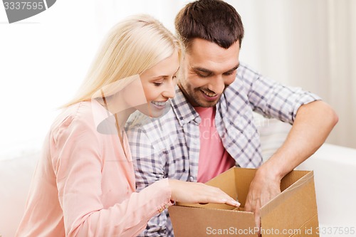 Image of happy couple with parcel box at home