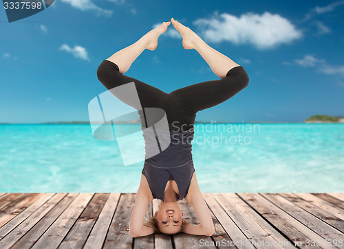 Image of happy young woman doing yoga exercise