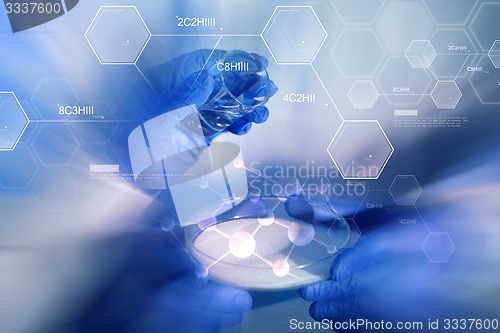 Image of close up of scientists hands with chemicals in lab