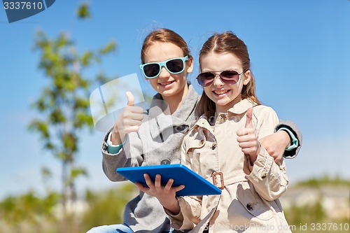 Image of happy girls with tablet pc showing thumbs up