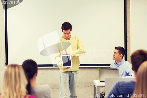 Image of group of smiling students and teacher in classroom