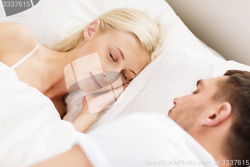 Image of happy couple sleeping in bed at home