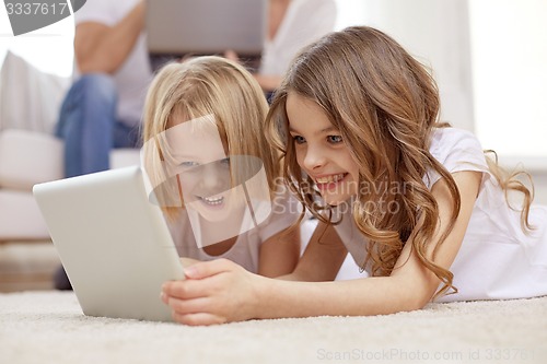 Image of happy little girls with tablet pc computer at home