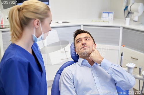 Image of male dentist with woman patient at clinic