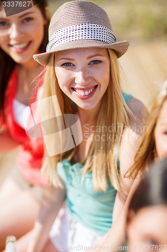 Image of girl with drink and friends on the beach