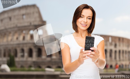 Image of woman taking selfie with smartphone over coliseum