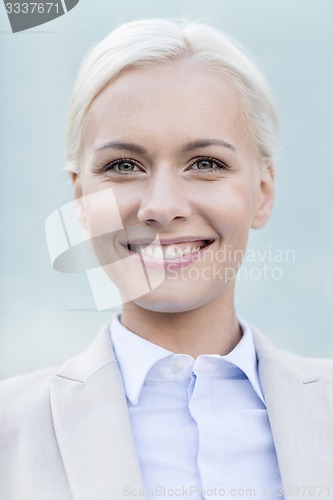 Image of young smiling businesswoman over office building