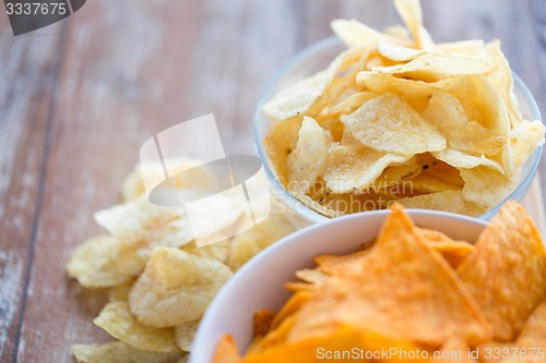 Image of close up of potato crisps and corn nachos on table