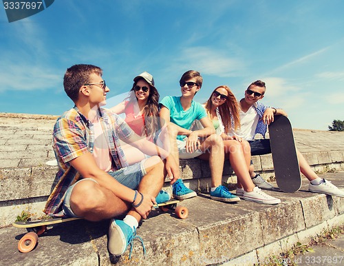 Image of group of smiling friends sitting on city street