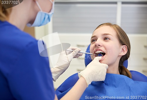 Image of female dentist checking patient girl teeth