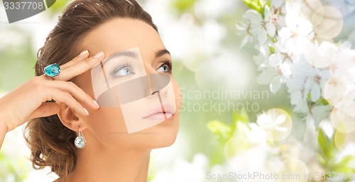 Image of close up of woman with cocktail ring and earrings