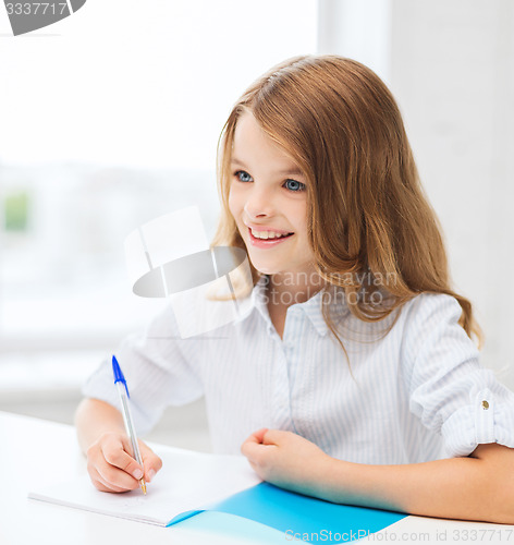 Image of student girl writing in notebook at school