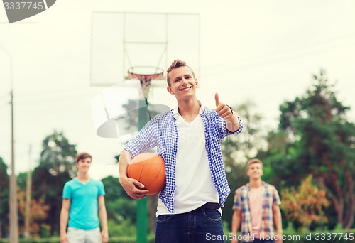 Image of group of smiling teenagers playing basketball