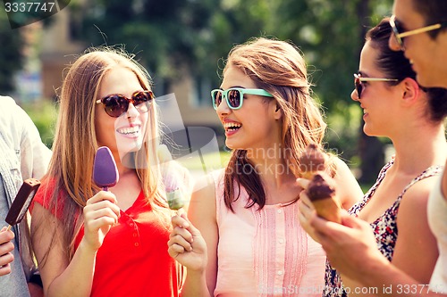 Image of group of smiling friends with ice cream outdoors