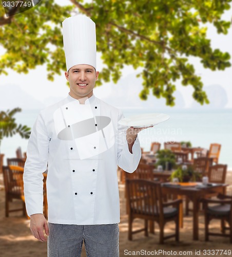 Image of happy male chef cook showing empty plate