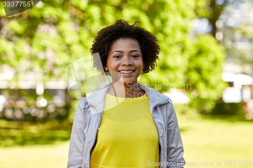 Image of happy african american young woman in summer park