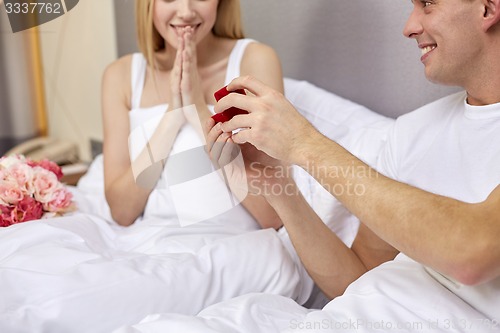 Image of close up of man giving woman engagement ring