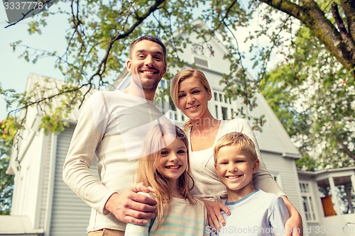 Image of happy family in front of house outdoors