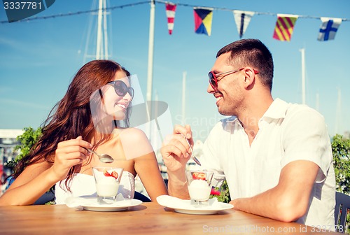 Image of smiling couple eating dessert at cafe