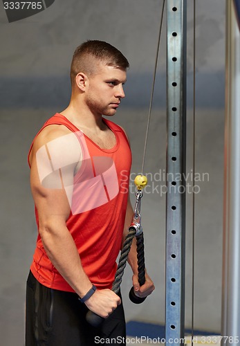 Image of man flexing muscles on cable machine gym