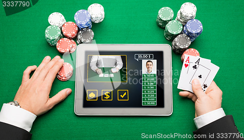 Image of casino player with cards, tablet pc and chips