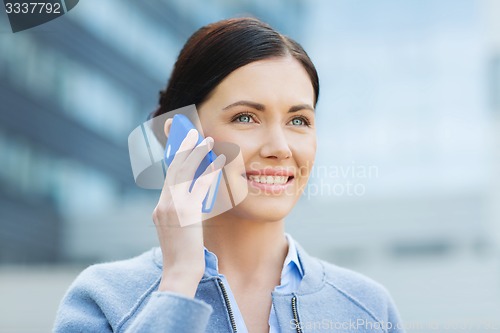 Image of young smiling businesswoman calling on smartphone