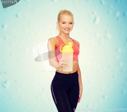 Image of smiling sporty woman with protein shake bottle