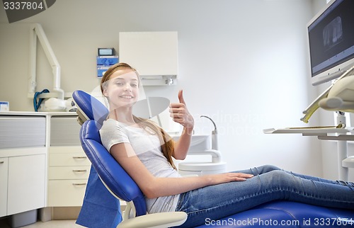 Image of happy patient girl showing thumbs up at clinic
