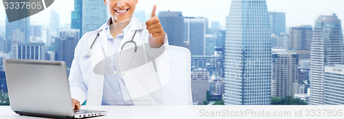 Image of african female doctor with laptop shows thumbs up