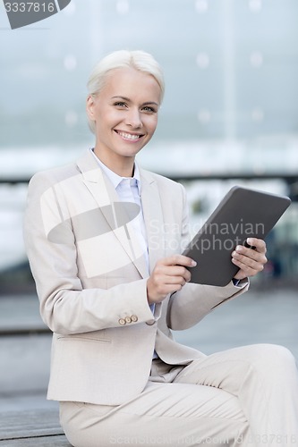 Image of smiling businesswoman with tablet pc outdoors