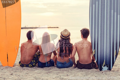 Image of group of friends in sunglasses with surfs on beach