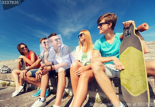 Image of group of smiling friends sitting on city street