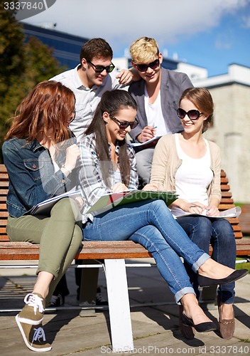 Image of group of happy students with notebooks at campus