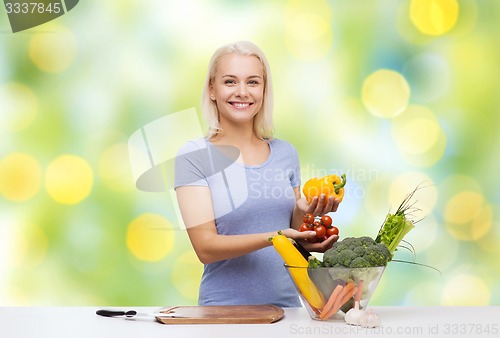 Image of smiling young woman cooking vegetables at home