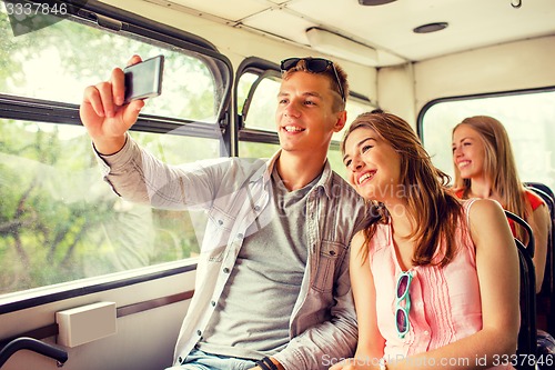 Image of smiling couple with smartphone making selfie