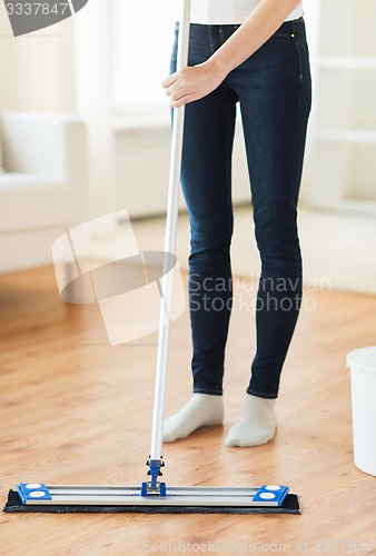 Image of close up of woman with mop cleaning floor at home