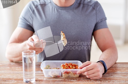 Image of close up of man with fork and water eating food