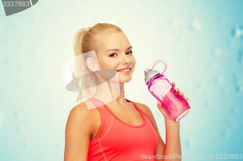 Image of smiling sporty woman with water bottle