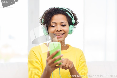 Image of happy african woman with smartphone and headphones