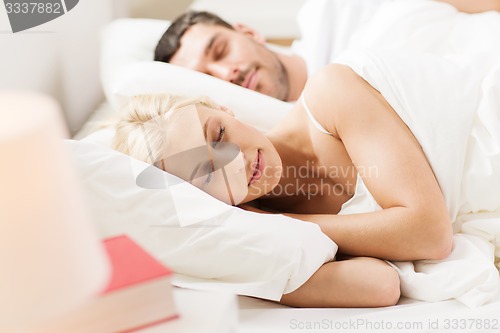 Image of happy couple sleeping in bed at home